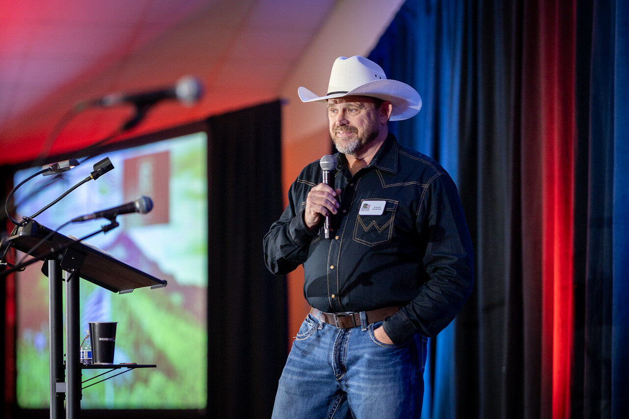 Dave speaking on stage in a cowboy hat